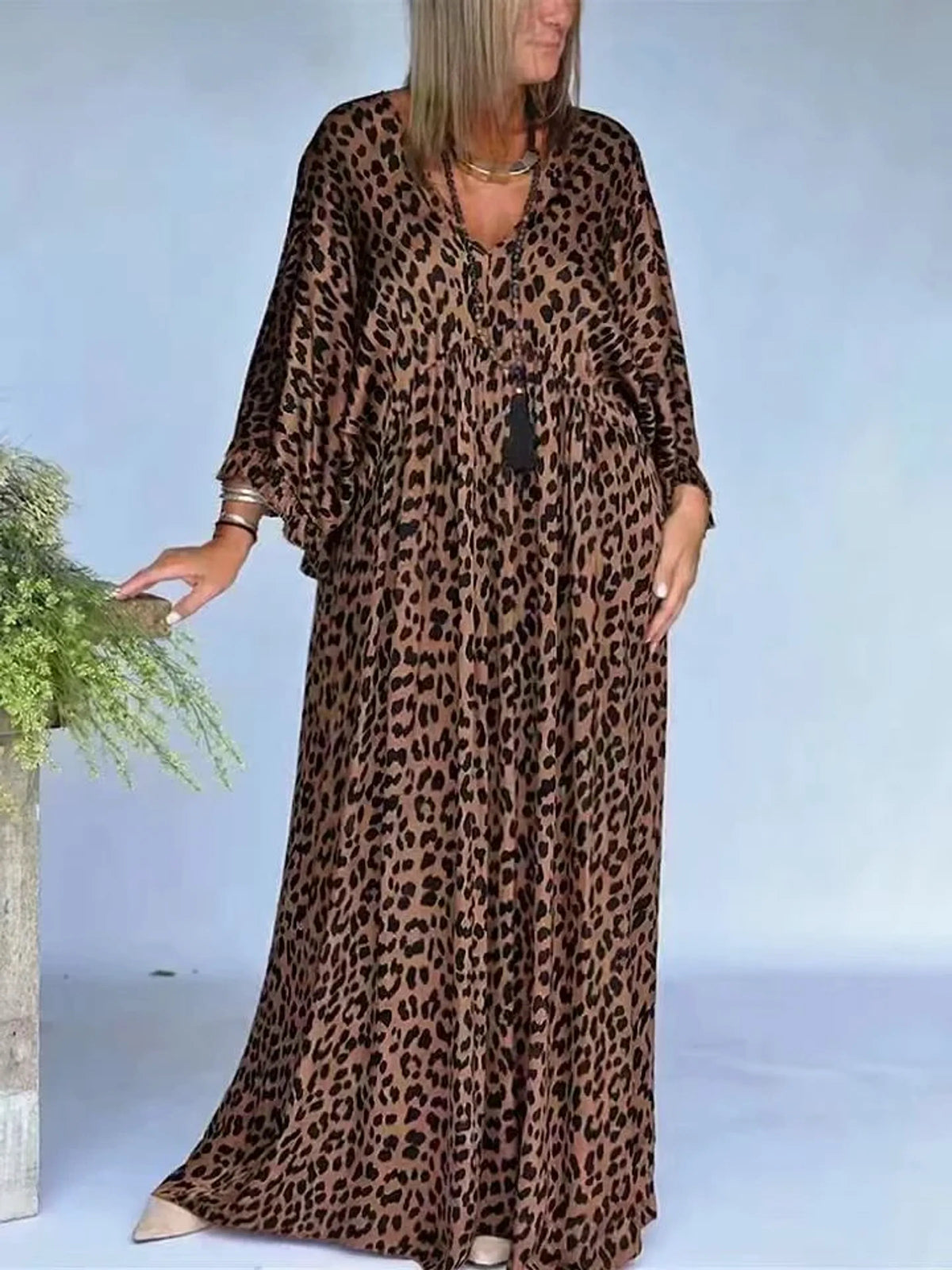 Women's leopard-print V-neck maxi dress in brown and black, front model view.