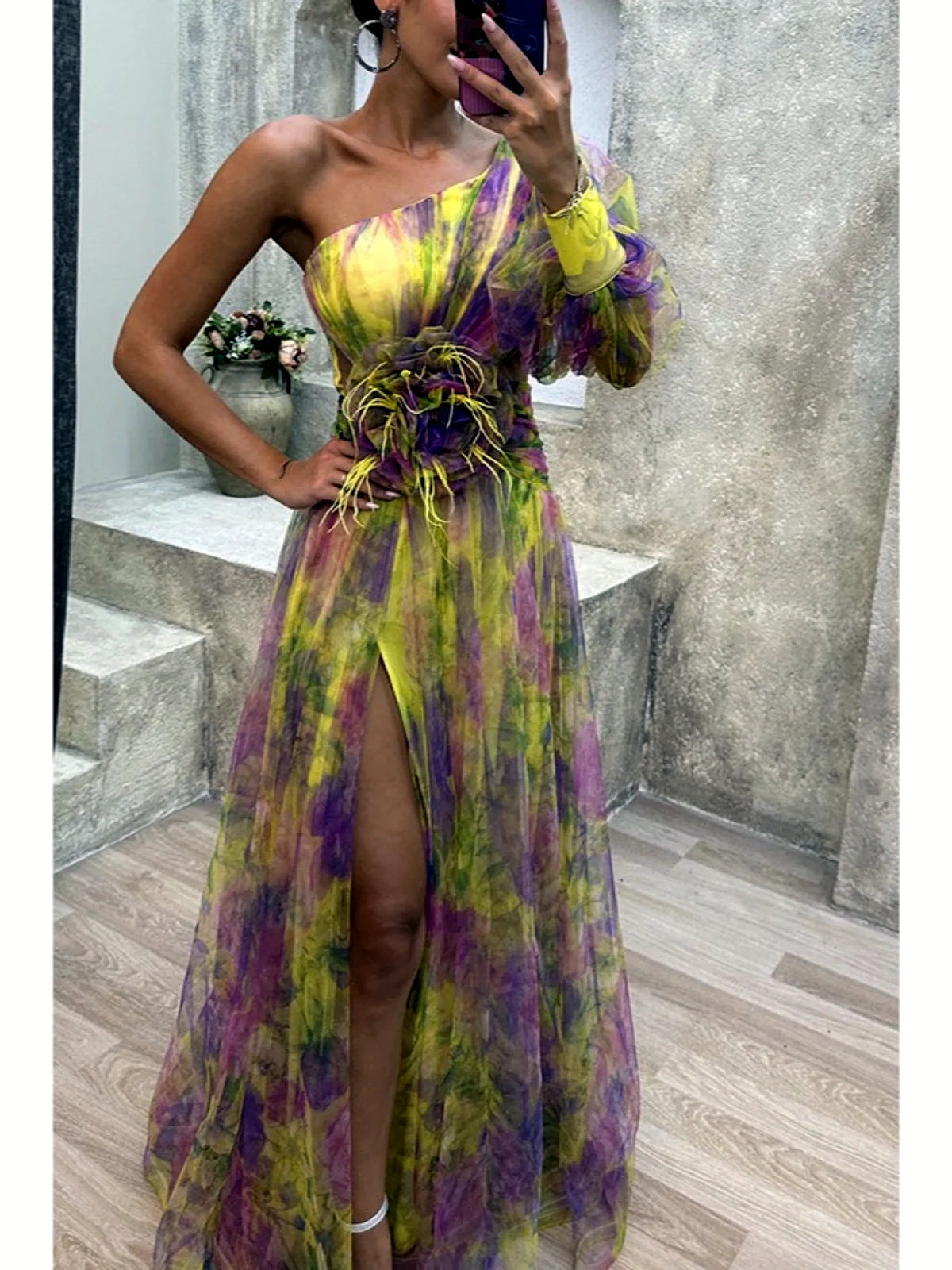 Women's printed one-shoulder floral-waist slit gown in yellow and purple, front mirror view.