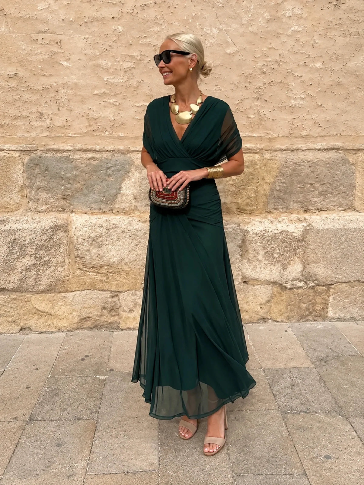 Women's ruched off-shoulder flowing dress in dark green, front model view.