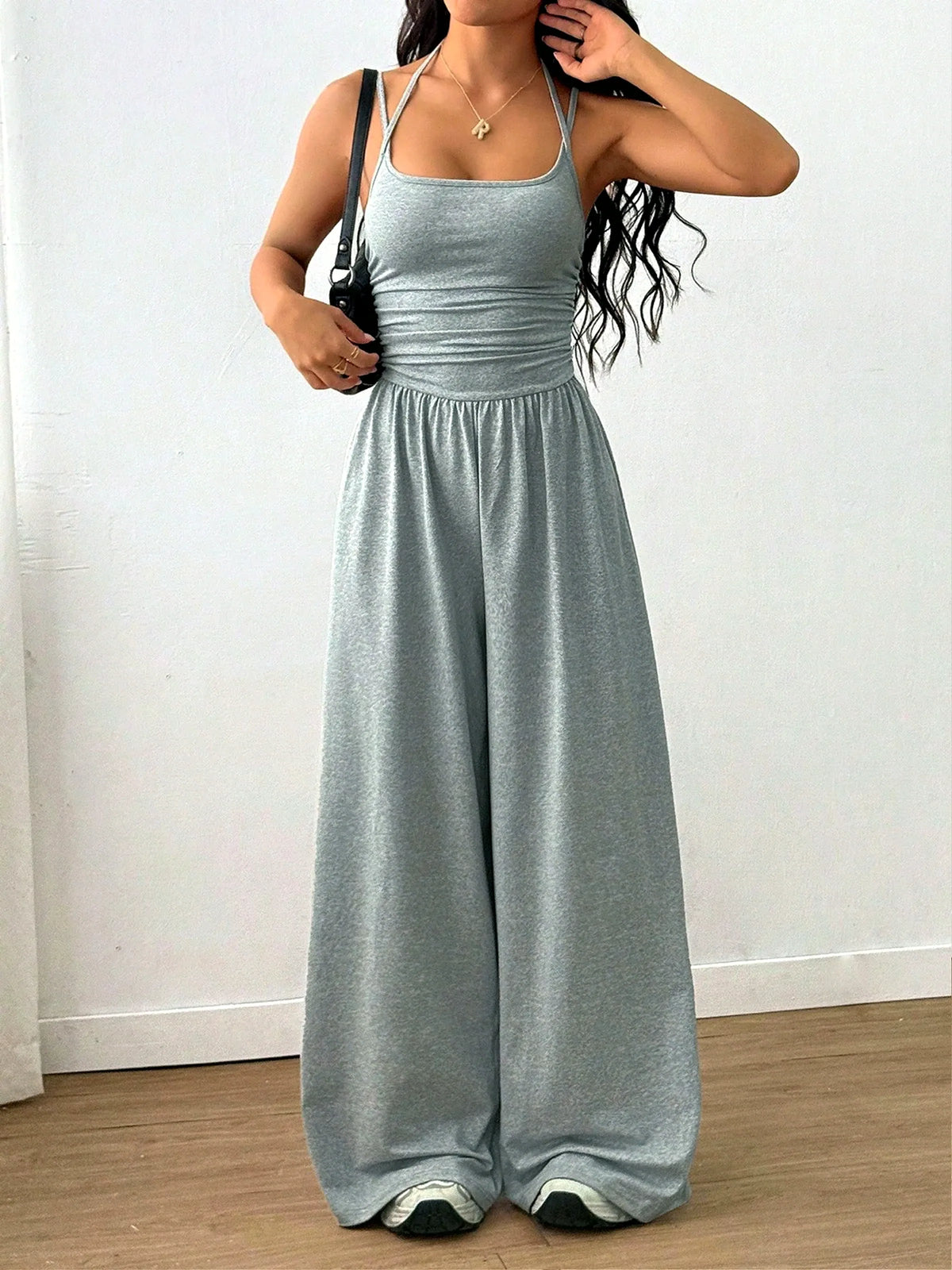 Women's sleeveless ruched-bodice wide-leg jumpsuit in gray, front model view.