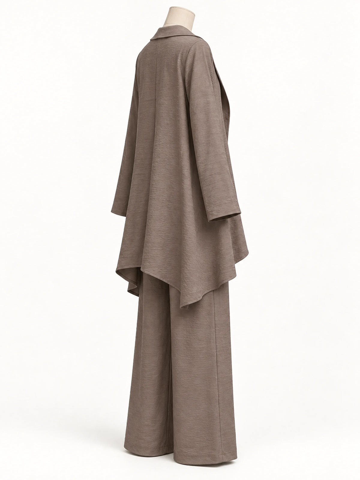 Back view of the taupe textured asymmetric outfit, showing the long open-front layer and wide-leg pants on a mannequin.