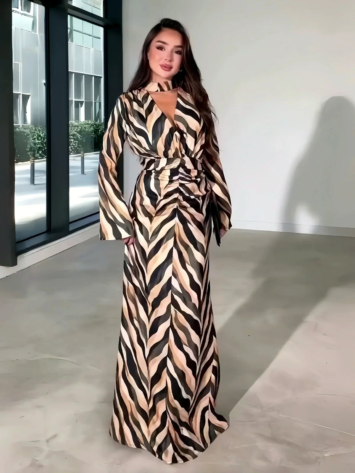 Women's zebra-print long-sleeve maxi dress in beige and black, front model view.