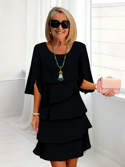 Women's layered ruffle relaxed midi dress in black, front model view.