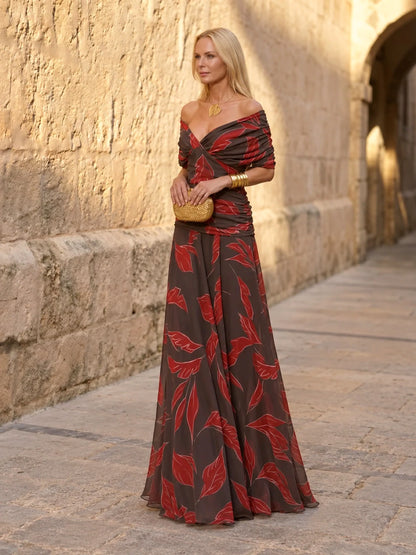 Women's ruched off-shoulder flowing dress in black and red leaf print, front model view.