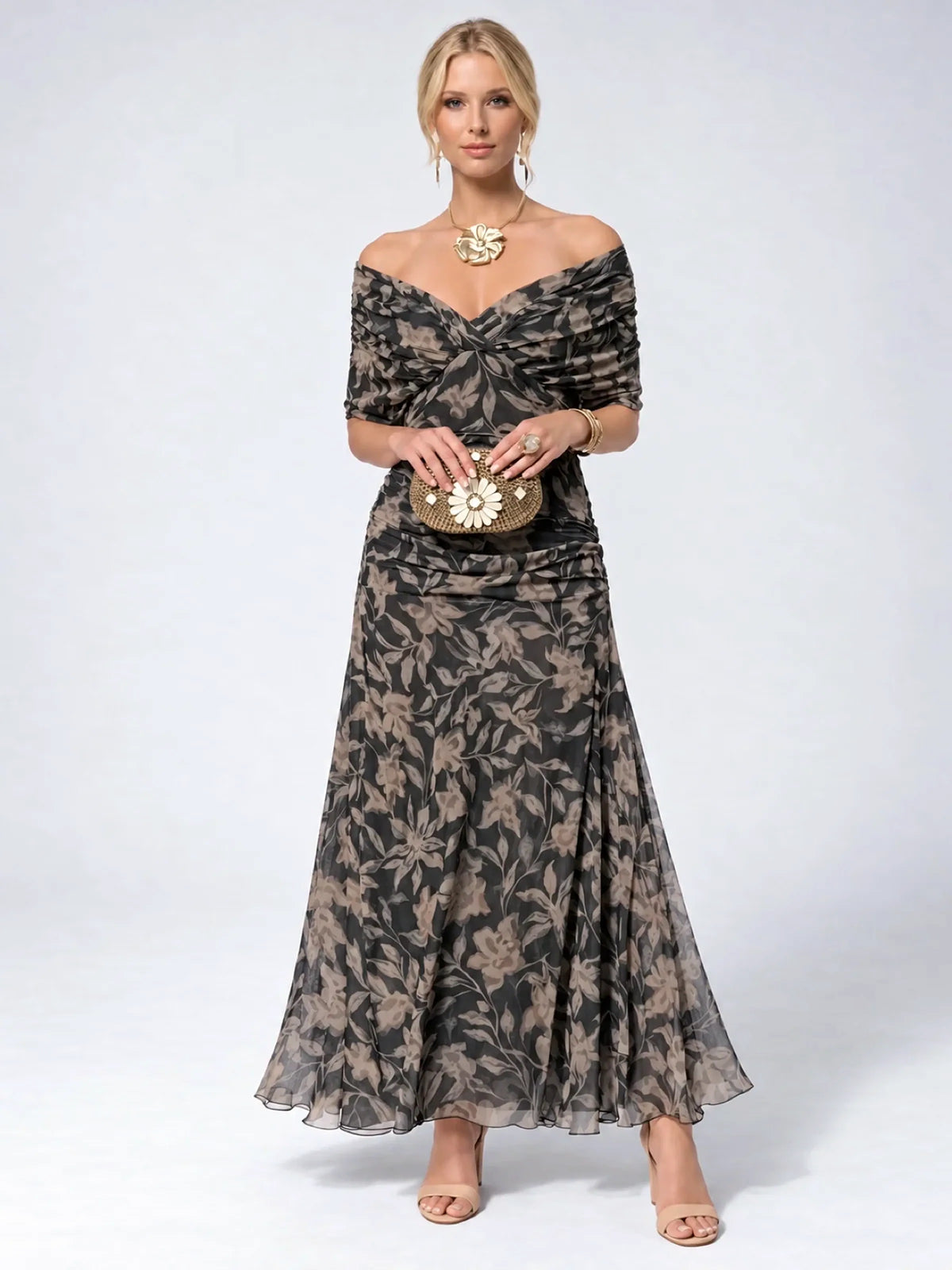 Women's ruched off-shoulder flowing dress in black floral print, front model view.