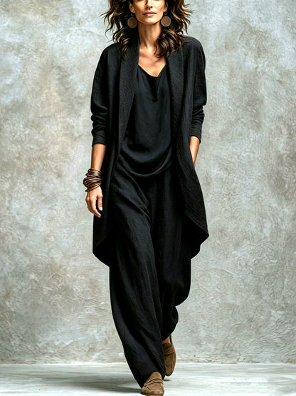 Women’s black textured asymmetric top and wide-leg pants set with an open-front layer, showing the relaxed fit.