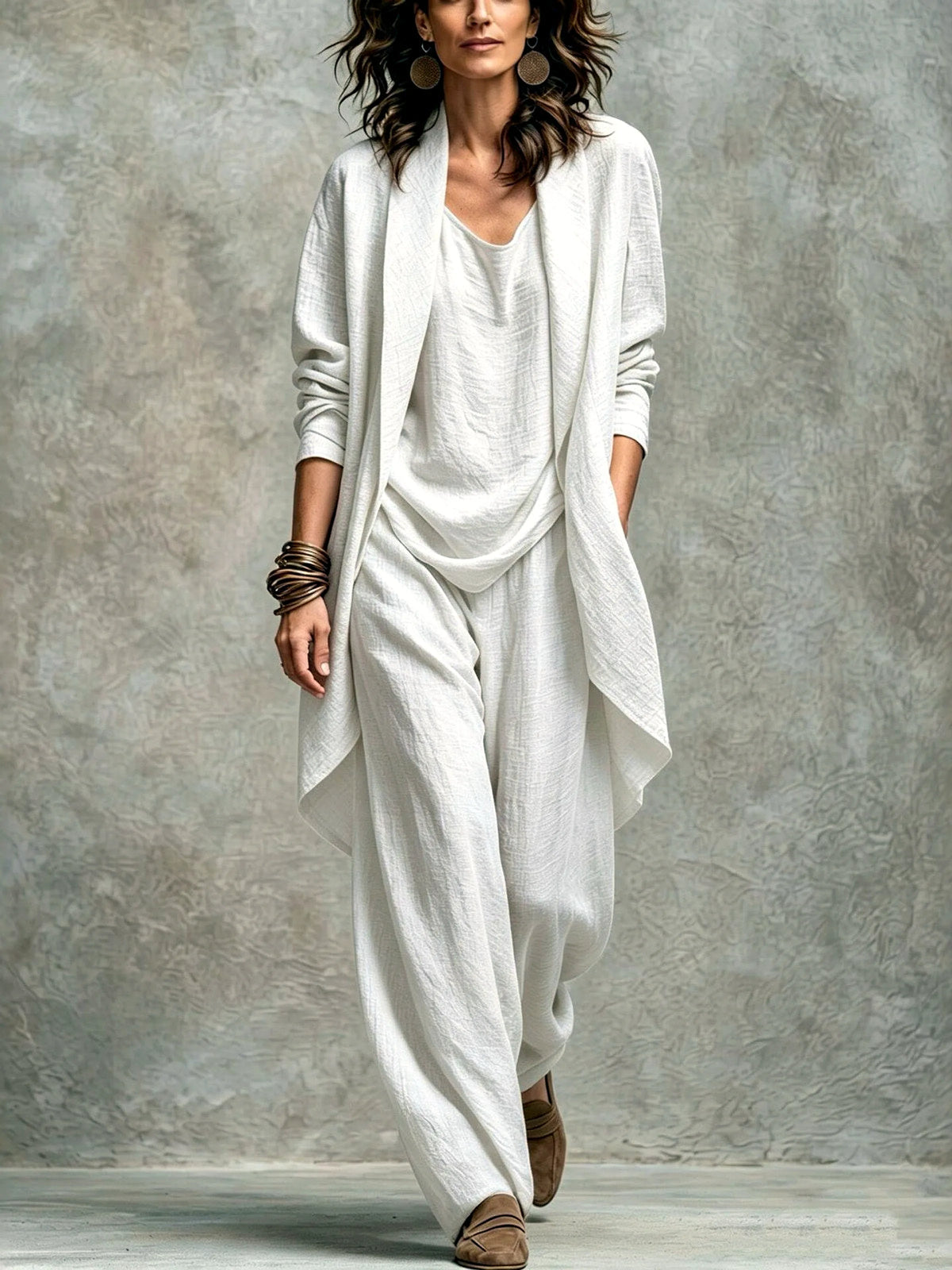 Women’s white textured asymmetric top and wide-leg pants set with an open-front layer, shown on a model.